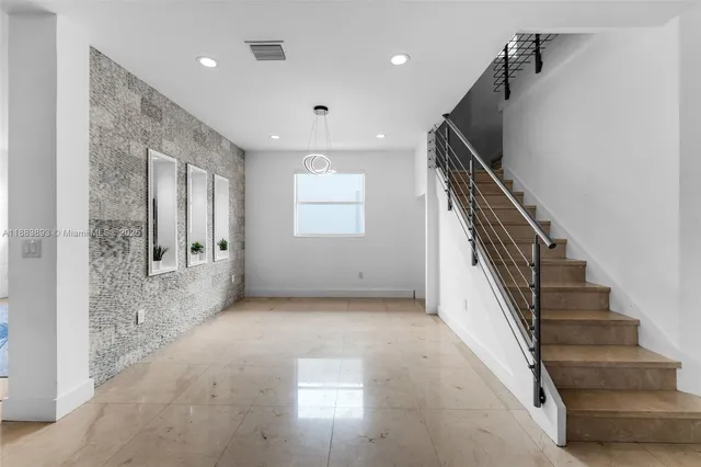a view of hallway with stairs and wooden floor