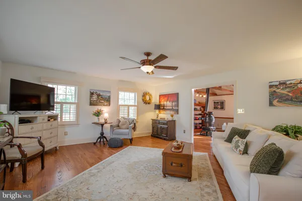 a living room with furniture and a large window with wooden floor
