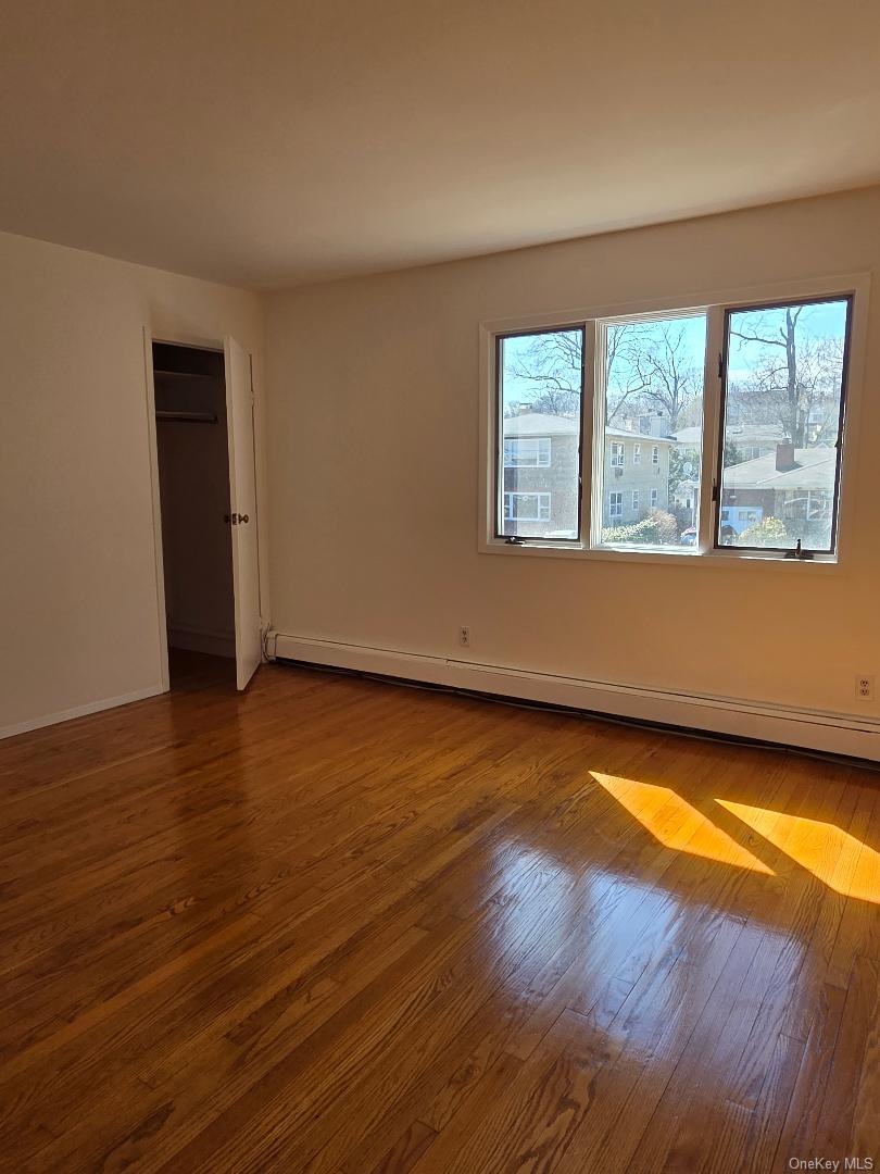 68 Kirkwood Road Port Washington, NY 11050 - Photo 7 of 9 a view of an empty room with wooden floor and a window