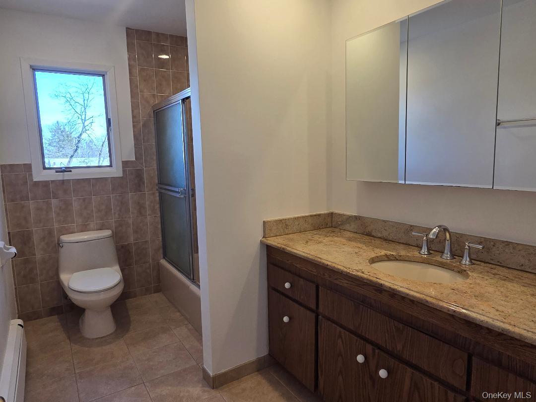 68 Kirkwood Road Port Washington, NY 11050 - Photo 9 of 9 a bathroom with a granite countertop sink toilet and mirror