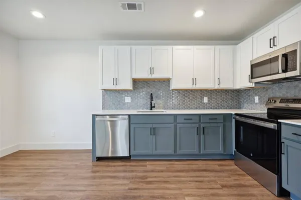 a kitchen with stainless steel appliances granite countertop a sink stove and microwave