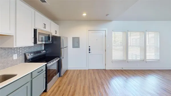 a kitchen with stainless steel appliances granite countertop a stove a sink and a refrigerator