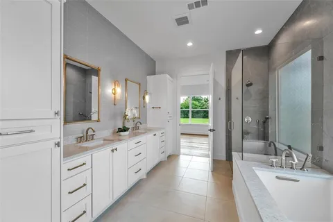 a bathroom with a double vanity sink tub and mirror