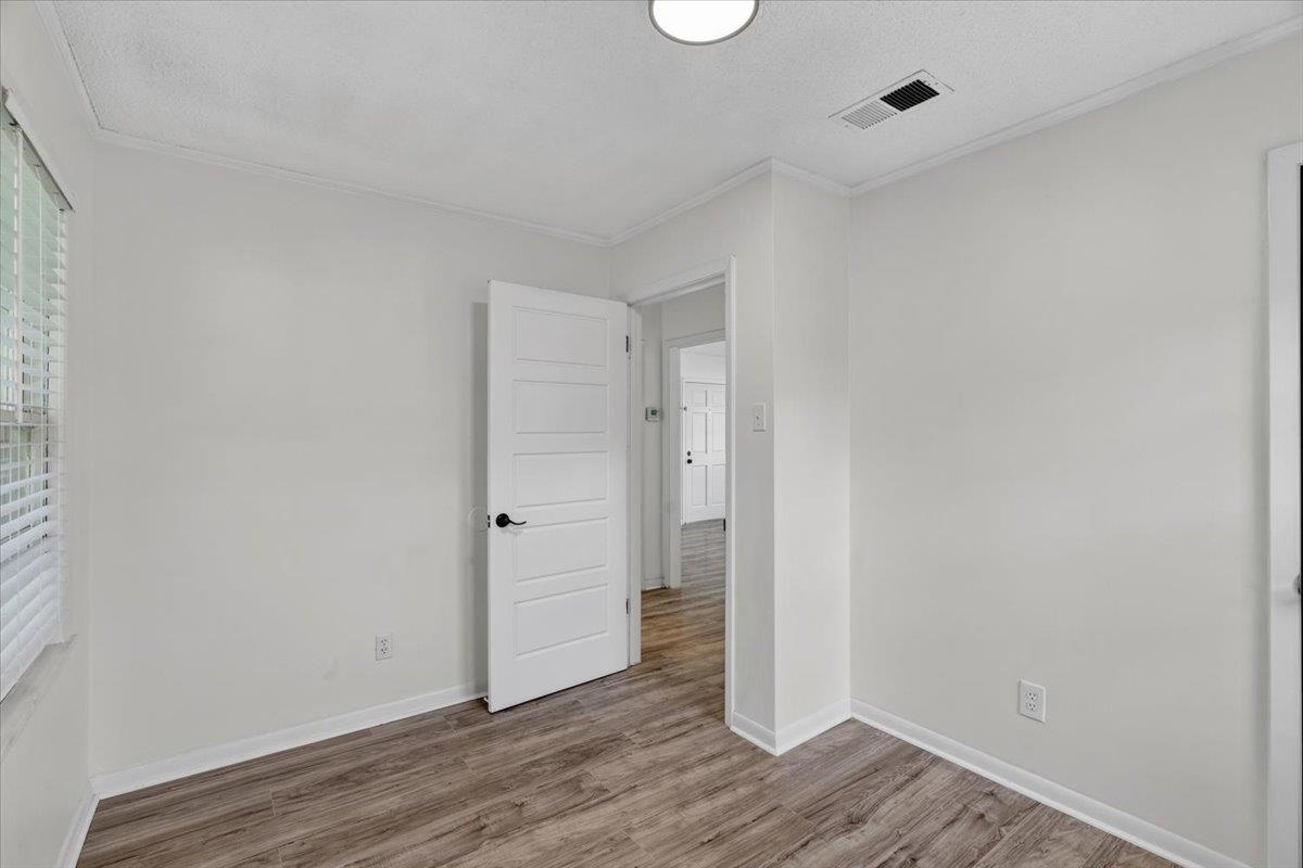 2717 Merle Street Memphis, TN 38118 - Photo 10 of 18 Bright room featuring wood-finish flooring, white walls, and a contemporary five-panel interior door