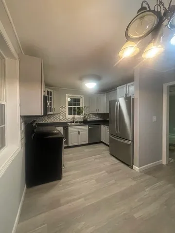 a kitchen with stainless steel appliances granite countertop a refrigerator a stove a sink and a stove