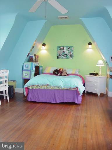 7007 Copeleigh Road Baltimore, MD 21212 - Photo 15 of 30 a bedroom with a bed dresser and a wooden floor