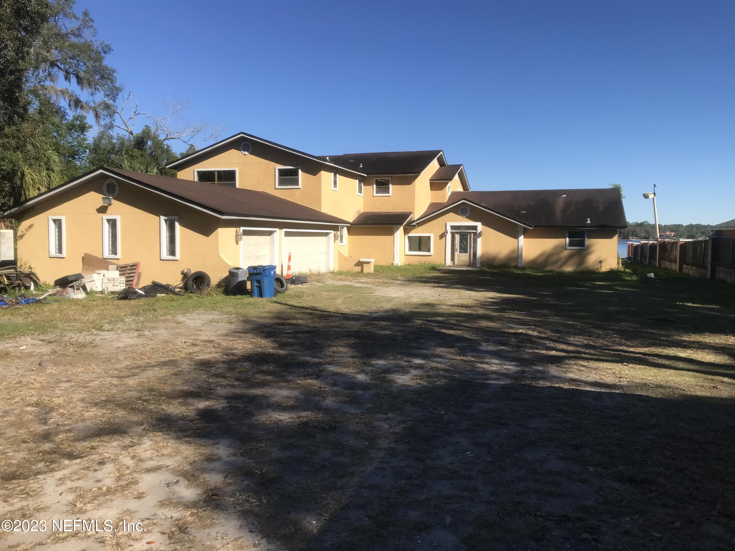 8063 Appian Way Jacksonville, FL 32208 - Photo 4 of 27 a view of a big house with a big yard and large trees