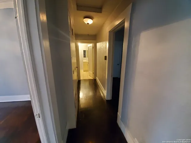 a view of a hallway with wooden floor