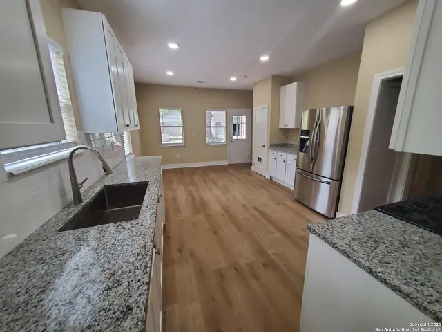 a view of a refrigerator in kitchen and a sink