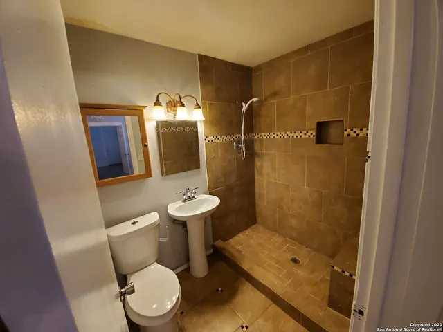 a bathroom with a toilet a sink and shower