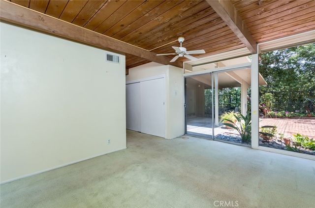 a view of a backyard with chair and potted plants