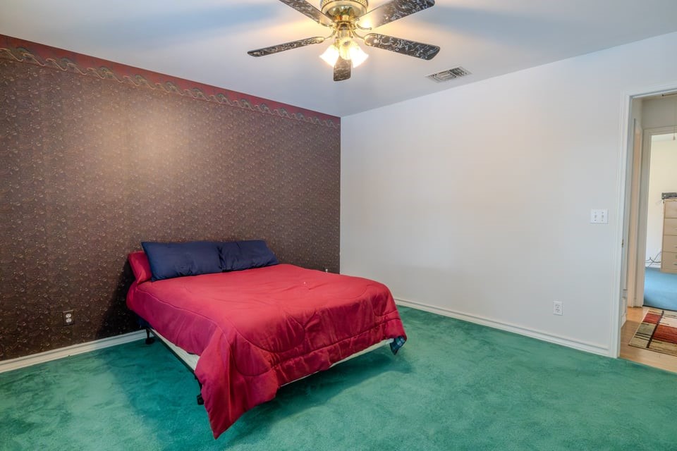 483 Riverside Drive Palacios, TX 77465 - Photo 16 of 41 a bedroom with a bed and a chandelier