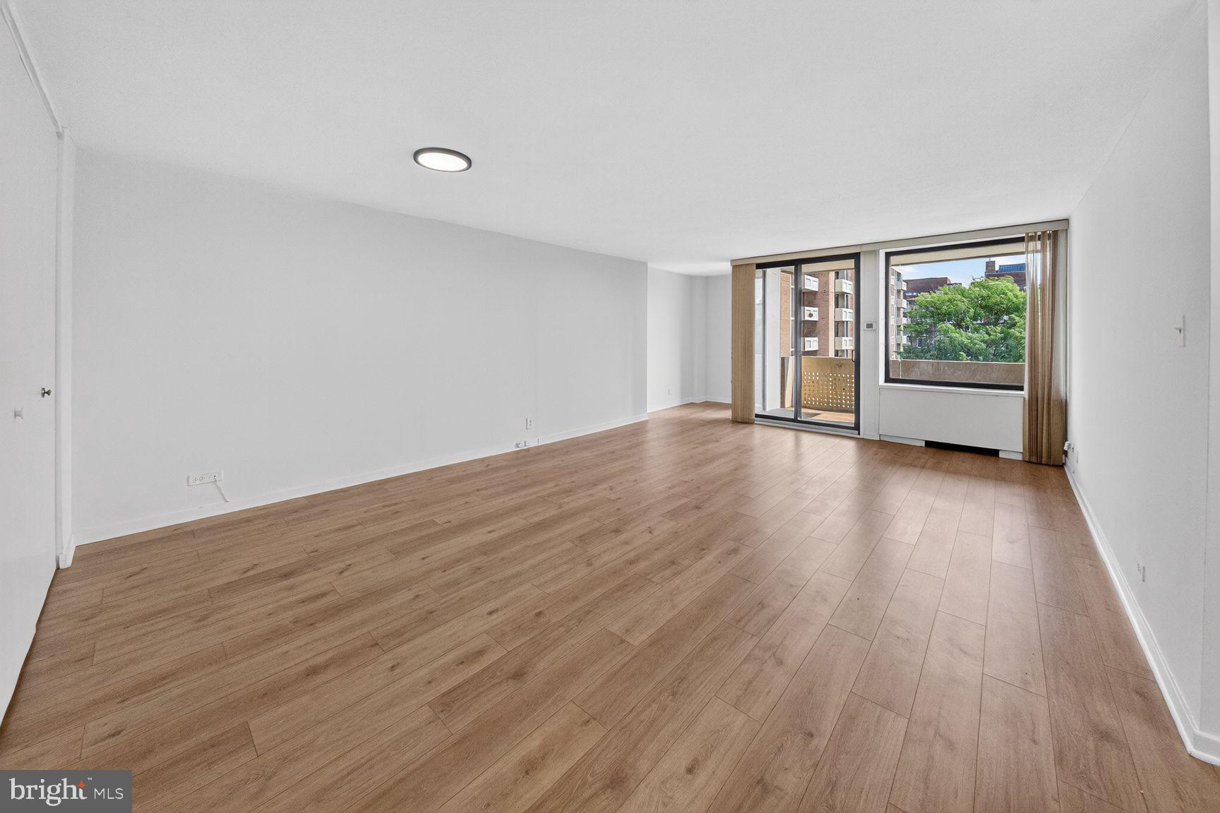 490 M Street Southwest, Unit W505 Washington, DC 20024 - Photo 17 of 18 a view of an empty room with wooden floor and a window