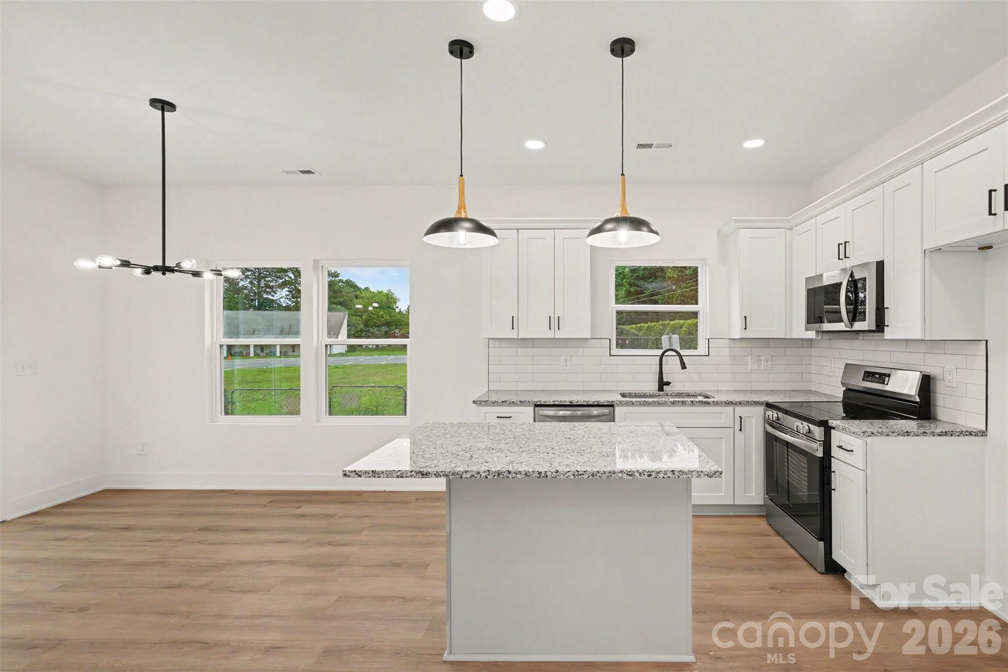 7521 Lawyers Road Charlotte, NC 28227 - Photo 15 of 35 a kitchen with stainless steel appliances granite countertop a sink a window and chairs