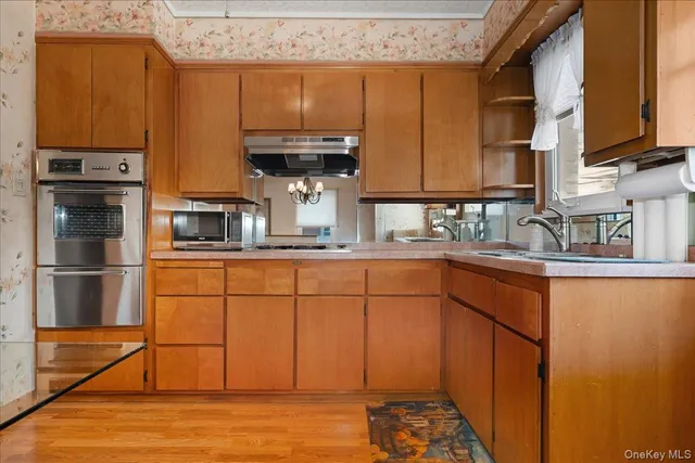 a kitchen with stainless steel appliances granite countertop a sink stove and cabinets