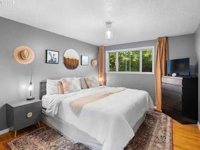 a bedroom with a bed and a lamp on dresser