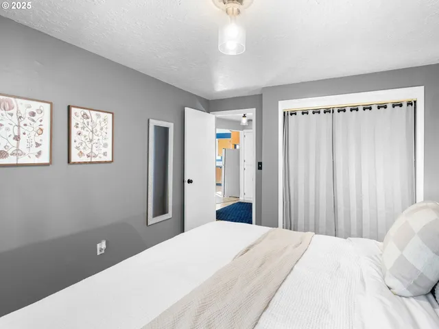 a bedroom with a large bed and a chandelier