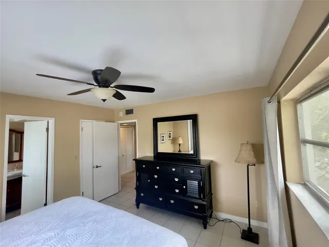 a bedroom with a bed and a flat tv screen on dresser