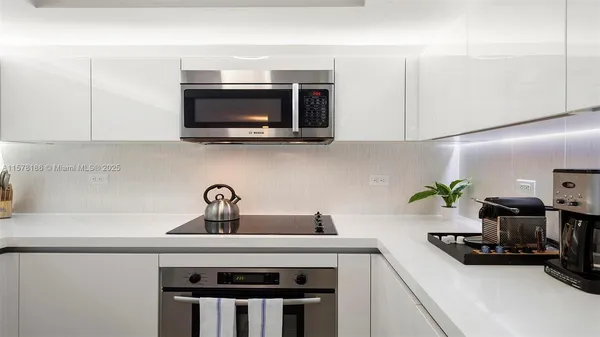a kitchen with a sink a microwave and cabinets