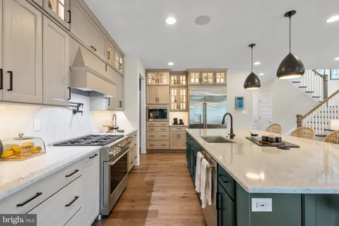 a kitchen with stainless steel appliances granite countertop a sink a stove and a wooden floors
