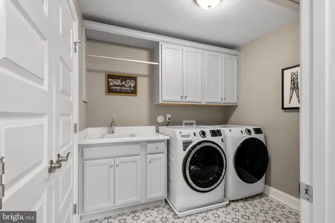 a utility room with sink dryer and washer