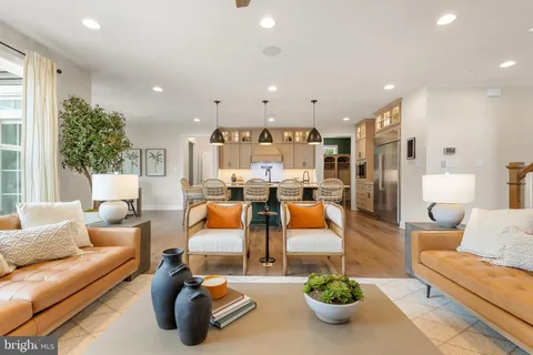 a living room with furniture kitchen view and a large window