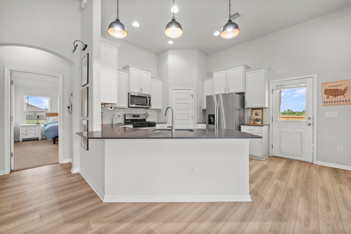 352 Backstays Loop Kyle, TX 78640 - Photo 13 of 39 a large kitchen with stainless steel appliances kitchen island a large counter top and a wooden floors