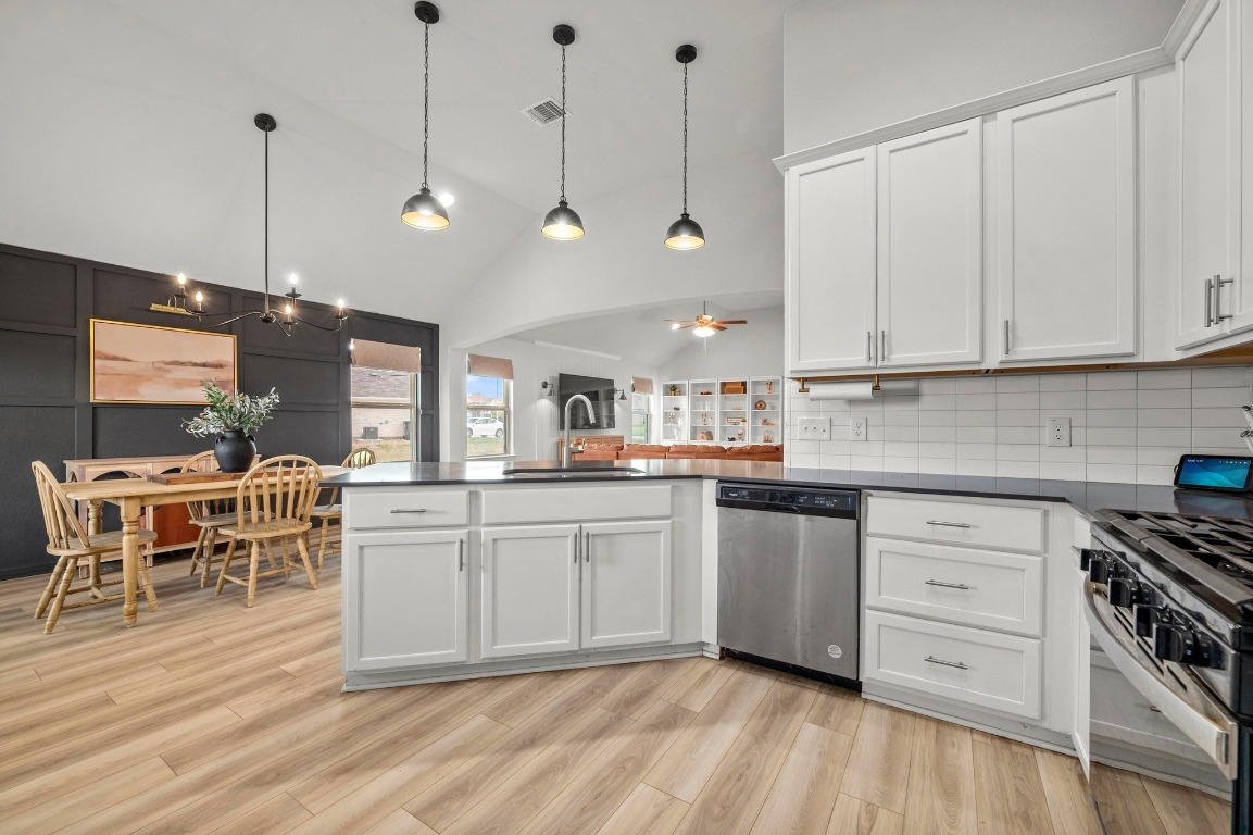 352 Backstays Loop Kyle, TX 78640 - Photo 15 of 39 a kitchen with stainless steel appliances granite countertop a stove a sink dishwasher and a refrigerator with wooden floor