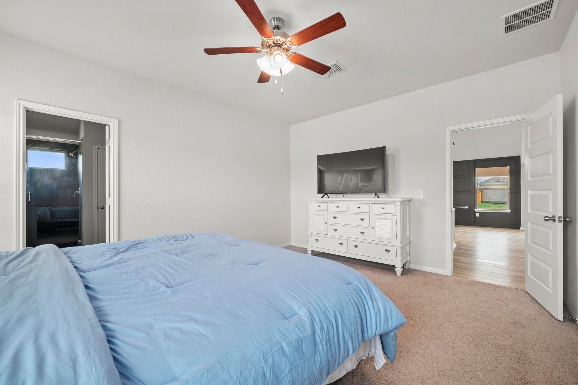 352 Backstays Loop Kyle, TX 78640 - Photo 18 of 39 a bedroom with a bed a large mirror and a flat tv screen on dresser