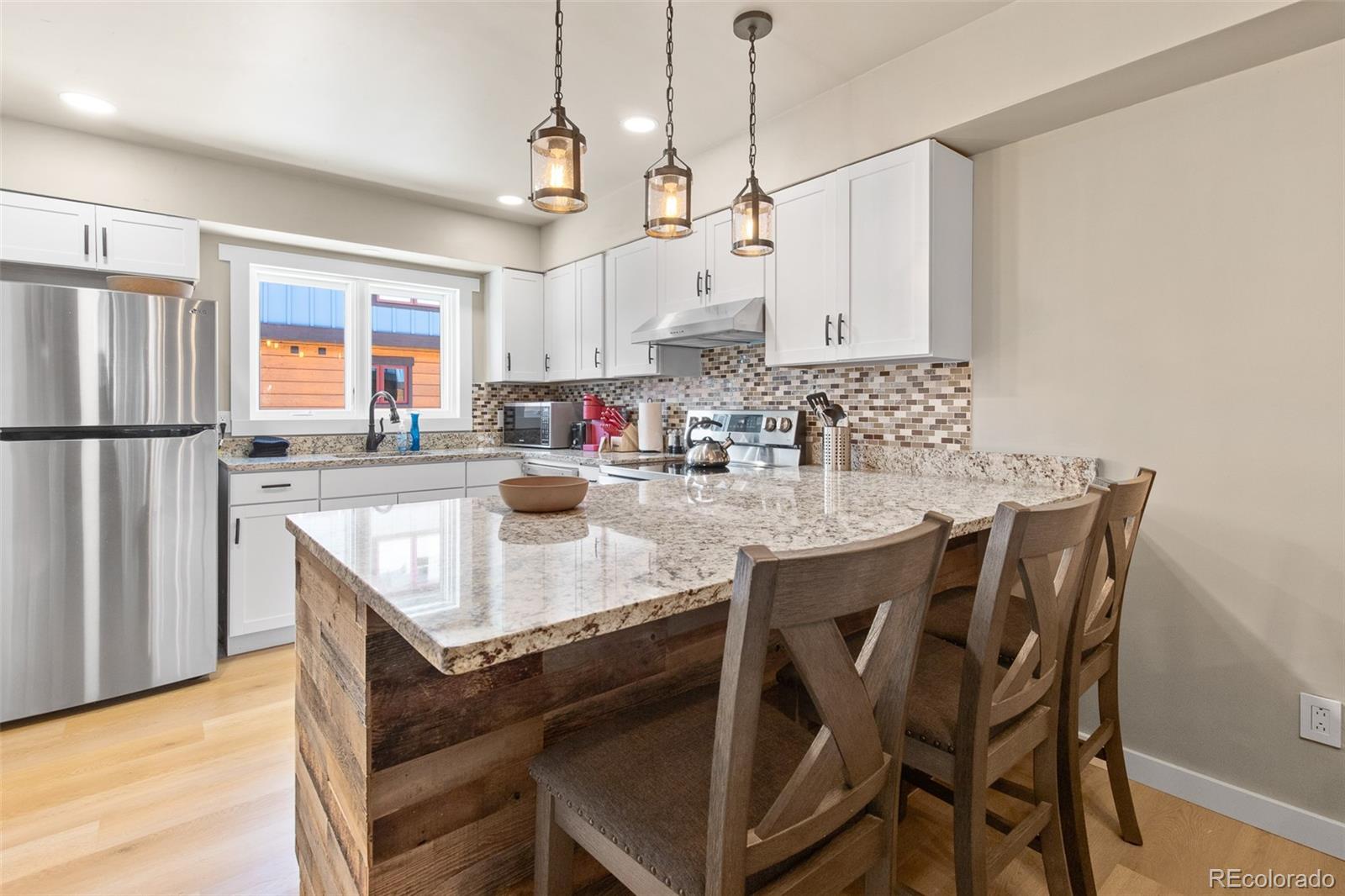 200 Primrose Path, Unit 11 Breckenridge, CO 80424 - Photo 8 of 32 a kitchen with stainless steel appliances granite countertop a sink a stove a refrigerator dining table and chairs