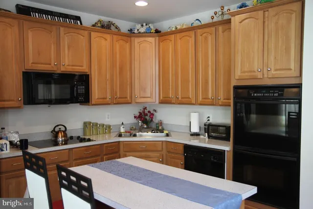 a kitchen with stainless steel appliances a stove a sink a microwave and cabinets
