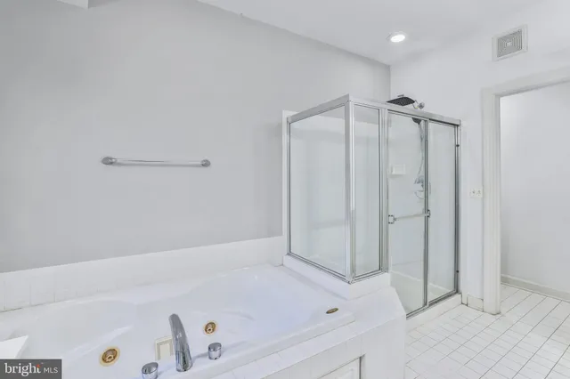 a bathroom with a sink double vanity granite tub shower and a mirror
