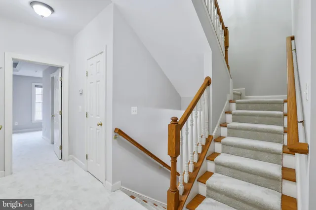 an empty room with a chandelier fan and windows
