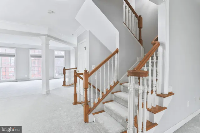 a view of staircase with lots of frames on wall and wooden floor