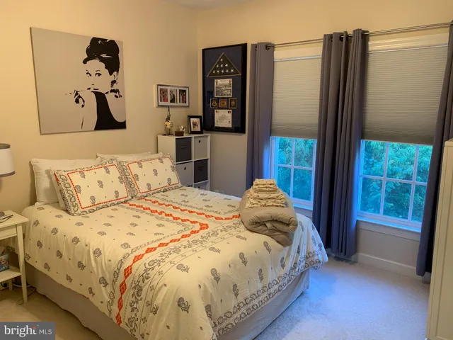 a bedroom with a bed and dresser with mirror