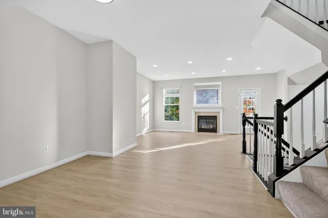 wooden floor in an empty room with fireplace and a window