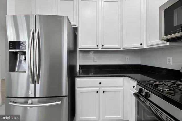 a kitchen with stainless steel appliances a refrigerator and a stove top oven
