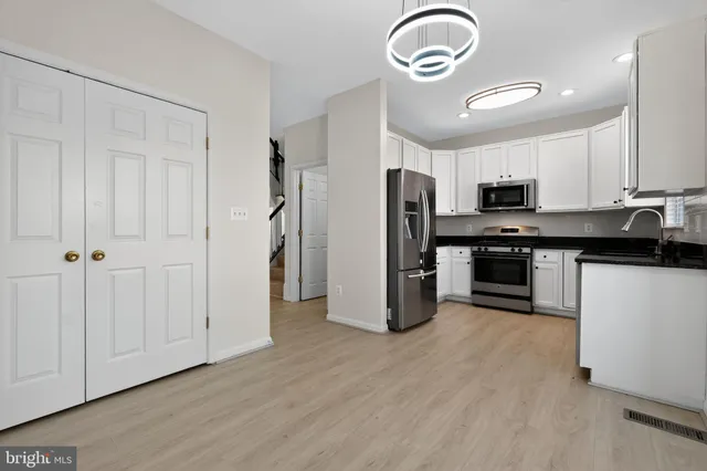 a kitchen with stainless steel appliances granite countertop a refrigerator a stove a sink and a microwave