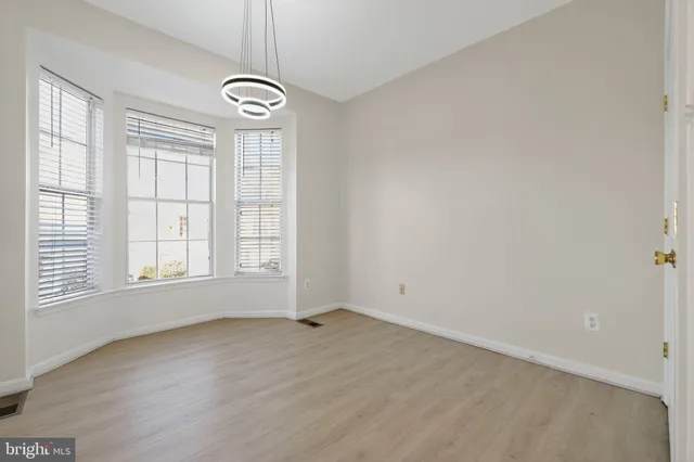 an empty room with windows and chandelier