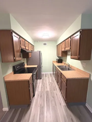 a kitchen with stainless steel appliances a sink stove and refrigerator