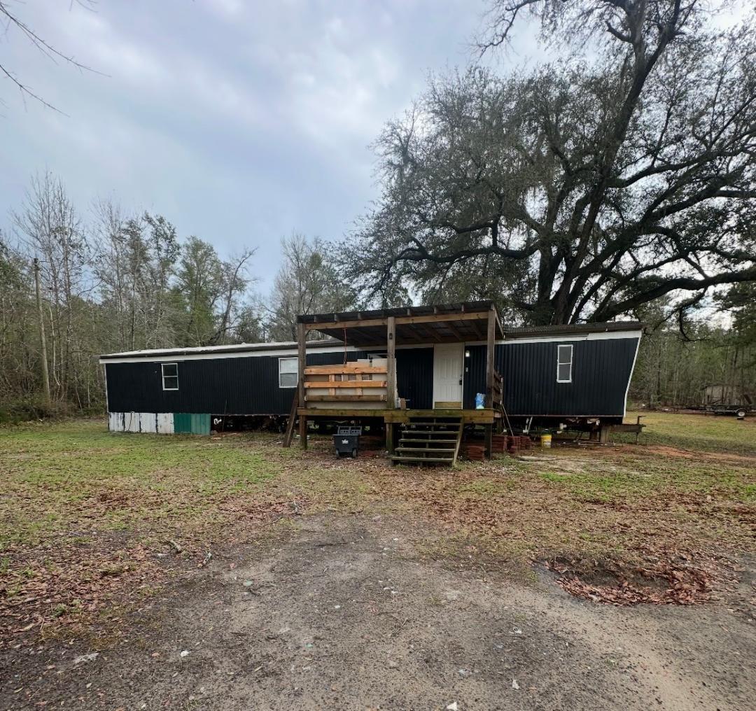 2984 B Goodman Hill Road Chipley, FL 32428 - Photo 1 of 14 a view of house in the backyard with large trees and wooden fence