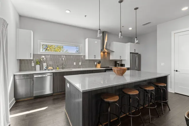 a kitchen with kitchen island a counter space a sink appliances and cabinets