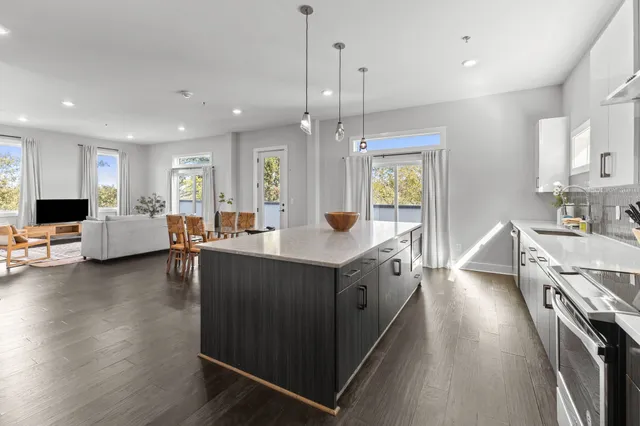 a large kitchen with stainless steel appliances kitchen island granite countertop a large island in the center