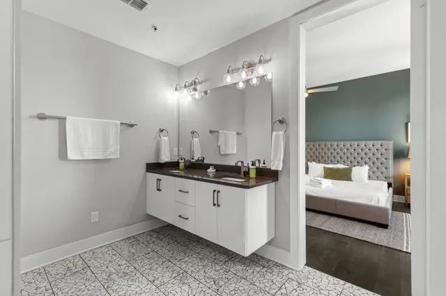 a spacious bathroom with a double vanity sink a mirror and shower