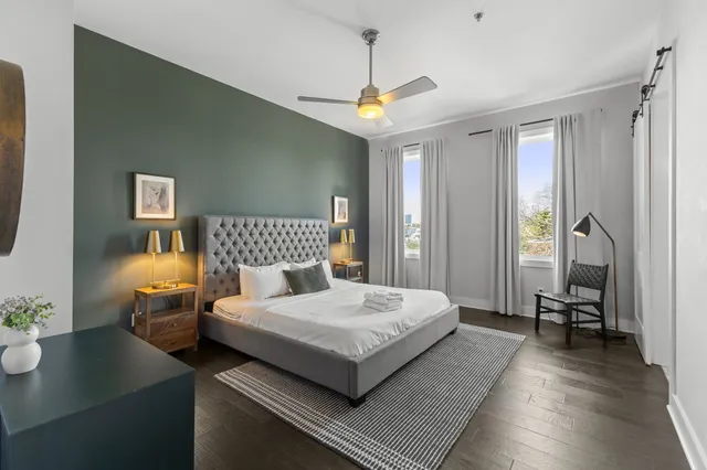 a bedroom with a large bed and a chandelier