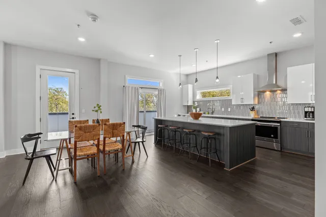 a kitchen with stainless steel appliances kitchen island wooden floors and white cabinets