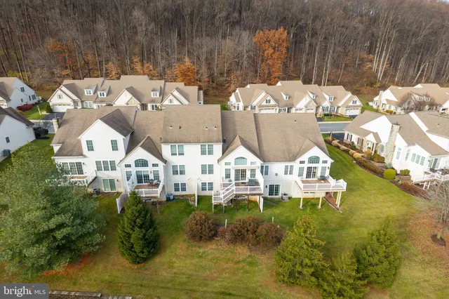 an aerial view of residential houses with outdoor space and swimming pool