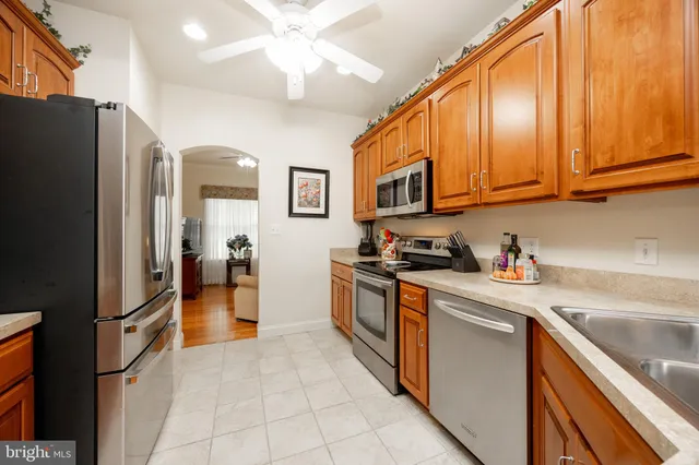 a kitchen with stainless steel appliances granite countertop a refrigerator a stove and a sink