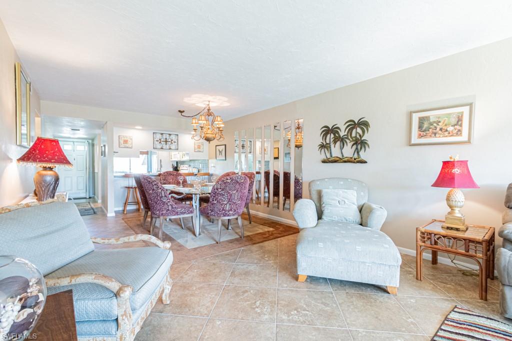 3662 Arctic Circle, Unit 201 Naples, FL 34112 - Photo 11 of 35 a living room with furniture and a dining table with rug kitchen