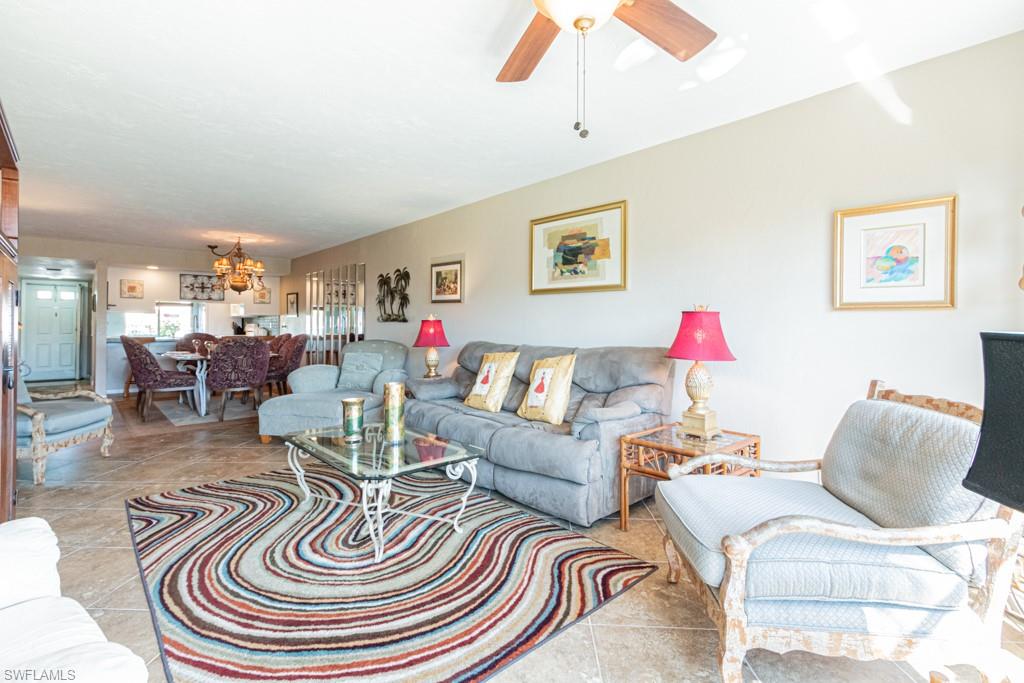 3662 Arctic Circle, Unit 201 Naples, FL 34112 - Photo 15 of 35 a living room with furniture and a chandelier